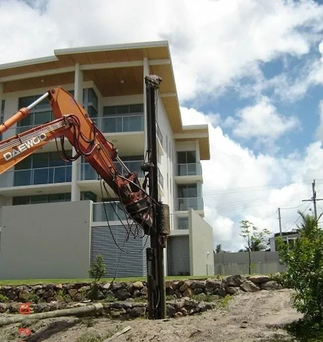 Boring rig installing steel screw piles into the ground for deep foundation support