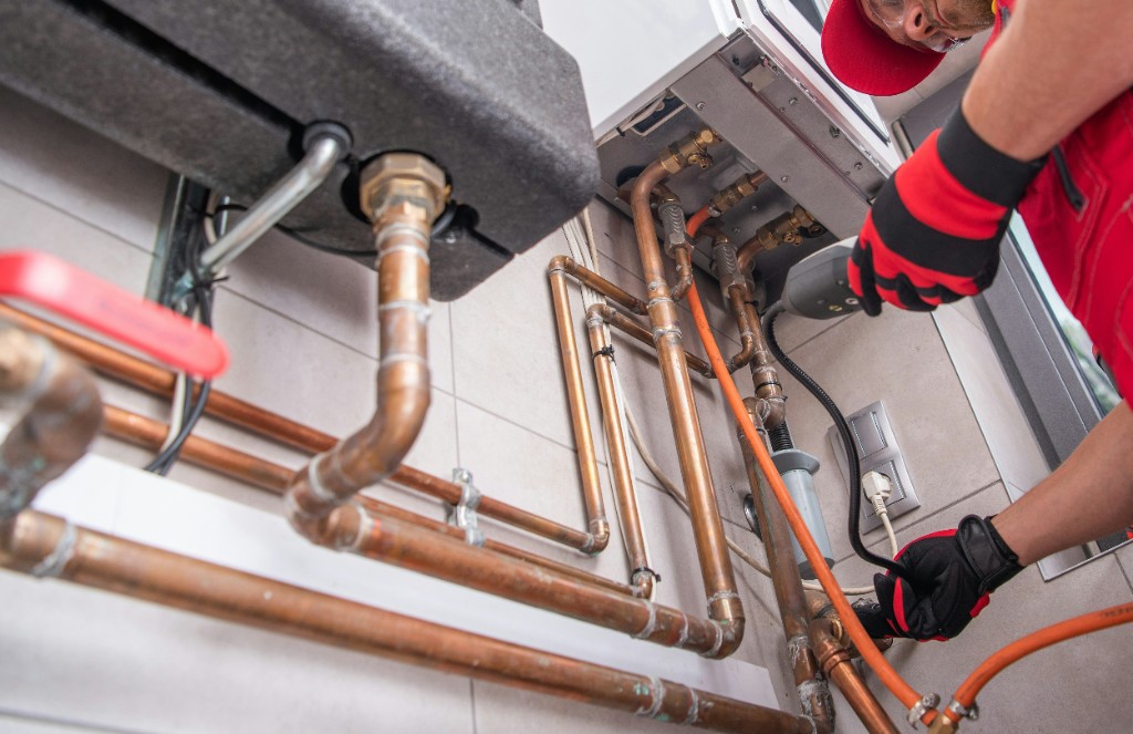 Plumber repairing the waste trap under a kitchen sink